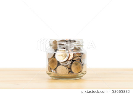 Coin glass jar container on wooden desk, saving Coin glass jar container on wooden desk, saving 58665883