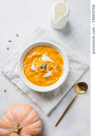 Pumpkin soup with cream on grey stone background. Pumpkin soup with cream on grey stone background. 58669766