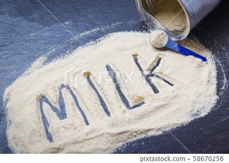 Milk powder on dark background / powdered milk can 58670256