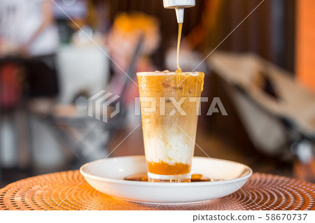 Iced coffee with milk in tall glasses. Iced coffee with milk in tall glasses. 58670737