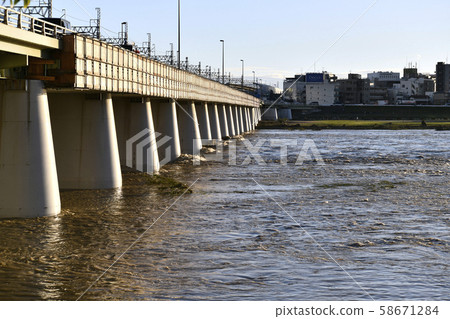 Tokyo cityscape in Japan Tama River with increased water and muddy water. (The back of the screen is the Kawasaki side, the front is the Futakotamagawa side) = evening on the 13th 58671284