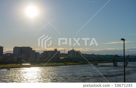 Tokyo cityscape in Japan Tama River with increased water and muddy water. (The back of the screen is the Kawasaki side, the front is the Futakotamagawa side) = evening on the 13th 58671285