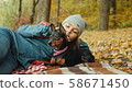 Girl relaxes in the autumn forest with her miniature pinscher 58671450