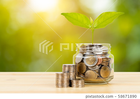 Coin glass jar container on wooden desk with Coin glass jar container on wooden desk with 58671890