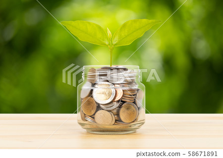 Coin glass jar container on wooden desk, saving Coin glass jar container on wooden desk, saving 58671891