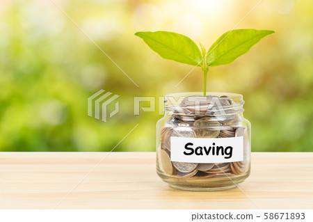Coin glass jar container on wooden desk with Coin glass jar container on wooden desk with 58671893