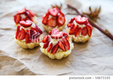 Very tasty muffins with fresh strawberries lie on 58673105