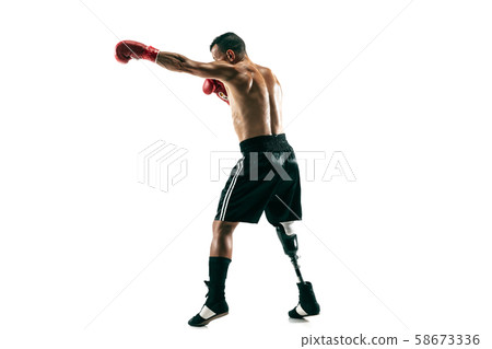 Full length portrait of muscular sportsman with prosthetic leg, copy space. Male boxer in red gloves Full length portrait of muscular sportsman with prosthetic leg, copy space. Male boxer in red gloves 58673336