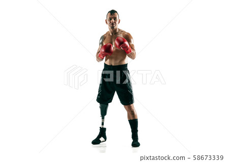 Full length portrait of muscular sportsman with prosthetic leg, copy space. Male boxer in red gloves Full length portrait of muscular sportsman with prosthetic leg, copy space. Male boxer in red gloves 58673339