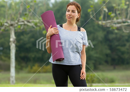 Young beautiful woman doing yoga exercise in green park. Healthy lifestyle and fitness concept. Young beautiful woman doing yoga exercise in green park. Healthy lifestyle and fitness concept. 58673472