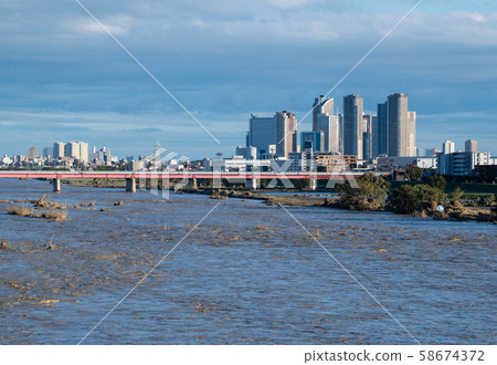 Tokyo cityscape in Japan One day after typhoon. Tamagawa River with increased water and muddy water. Musashi Kosugi on the right back = afternoon of 13th 58674372