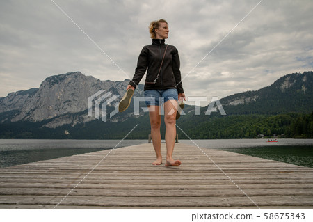 young woman with her dog enjoying the atmosphere of a mountain lake on the pier young woman with her dog enjoying the atmosphere of a mountain lake on the pier 58675343