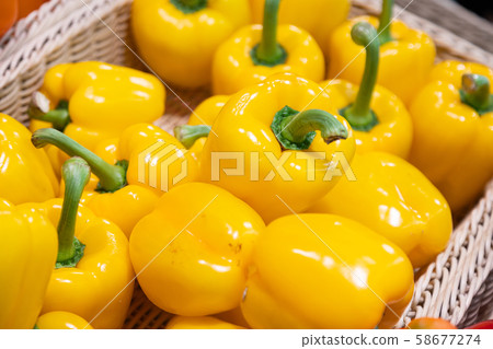 Close-up of fresh home-grown yellow sweet pepper in basket on supermarket counter Close-up of fresh home-grown yellow sweet pepper in basket on supermarket counter 58677274