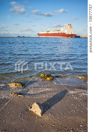 Beach with LNG tanker in distance at sunset. Beach with LNG tanker in distance at sunset. 58677787