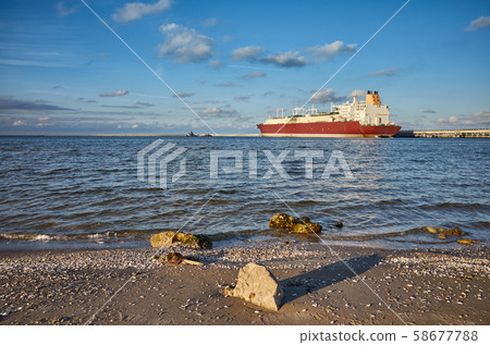 Beach with LNG tanker in distance at sunset. Beach with LNG tanker in distance at sunset. 58677788