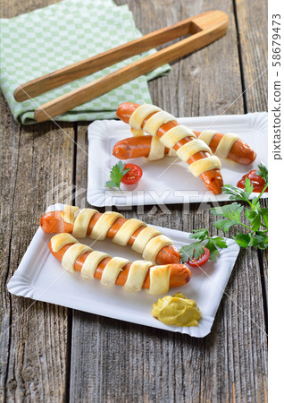 Baked Vienna sausages wrapped with puff pastry fresh from the oven,often served as a children’s meal Baked Vienna sausages wrapped with puff pastry fresh from the oven,often served as a children’s meal 58679473
