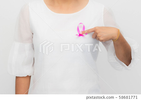 Pink ribbon on woman chest to support breast cancer cause. Healthcare, medicine and breast cancer awareness concept. Pink ribbon on woman chest to support breast cancer cause. Healthcare, medicine and breast cancer awareness concept. 58681771