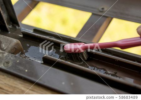 用粉色牙刷清潔窗扇導軌 用粉色牙刷清潔窗扇導軌 58683489