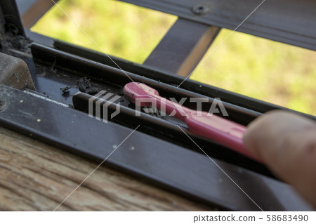 用粉色牙刷清潔窗扇導軌 用粉色牙刷清潔窗扇導軌 58683490