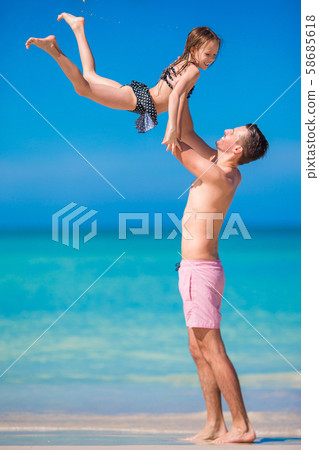 Little girl and happy dad having fun during beach vacation Little girl and happy dad having fun during beach vacation 58685618