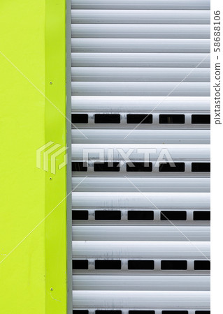 Fragment of roller-shutter door with a part of light green wall Fragment of roller-shutter door with a part of light green wall 58688106