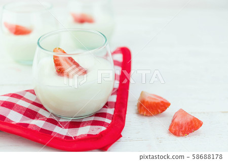 Original flavor yogurt with fresh strawberry in clear glass on white wood background Original flavor yogurt with fresh strawberry in clear glass on white wood background 58688178