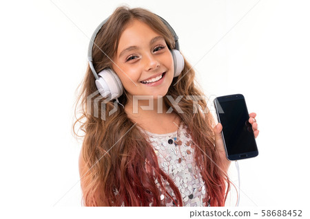Close-up photo of teenager with headphones on her head and phine with copyspace Close-up photo of teenager with headphones on her head and phine with copyspace 58688452