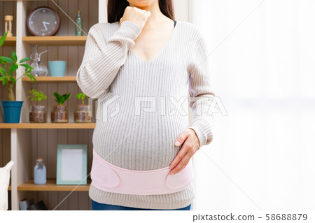 Pregnant woman wearing a pelvic belt 58688879
