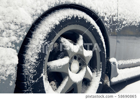 Cars tyre covered by snow on street in winter day Cars tyre covered by snow on street in winter day 58690865