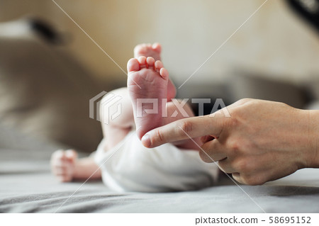 Mother holding newborn baby feet in hands Mother holding newborn baby feet in hands 58695152