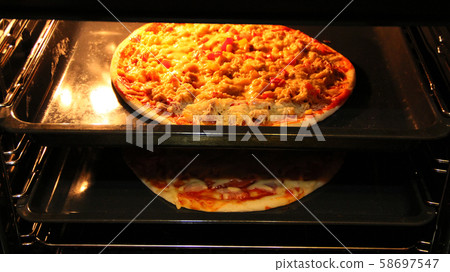 Cook preparing delicious pizza in oven. Cooking 58697547