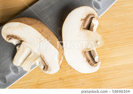 Fresh brown mushroom on light wood 58698304