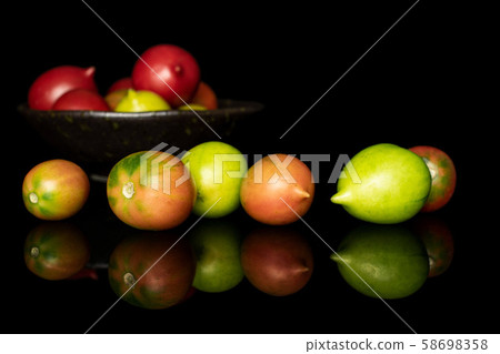 Fresh tomato de barao isolated on black glass 58698358