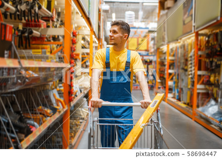 Builder with cart at the shelf in hardware store