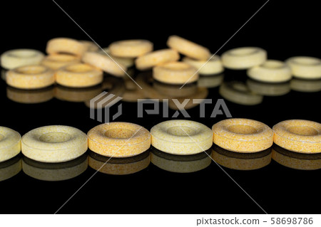 Pale round candy isolated on black glass Pale round candy isolated on black glass 58698786
