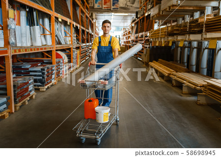 Male builder carries building materials in a cart 58698945