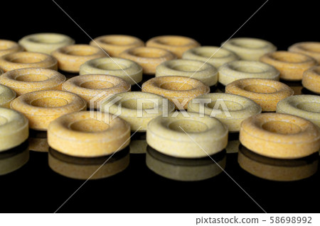 Pale round candy isolated on black glass Pale round candy isolated on black glass 58698992
