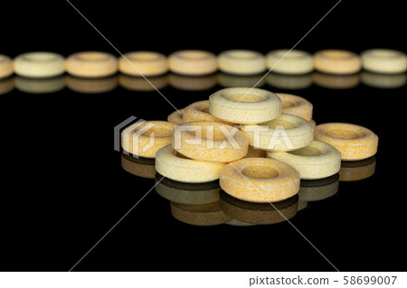 Pale round candy isolated on black glass Pale round candy isolated on black glass 58699007
