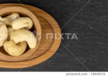 Fresh cashew nut on grey stone 58699234