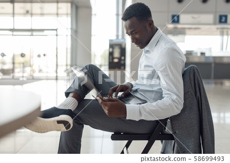 Black businessman using laptop in car showroom Black businessman using laptop in car showroom 58699493