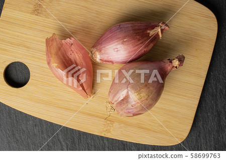 Fresh brown shallot on grey stone Fresh brown shallot on grey stone 58699763