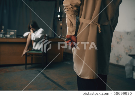 Psychiatrist with syringe and crazy female patient 58699950