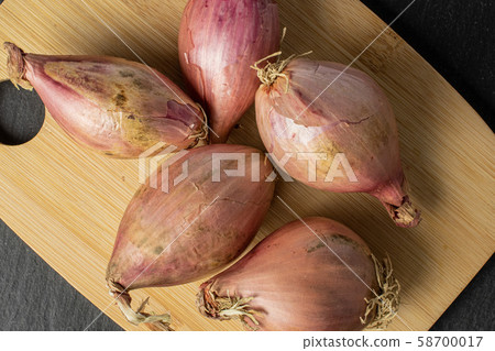 Fresh brown shallot on grey stone Fresh brown shallot on grey stone 58700017