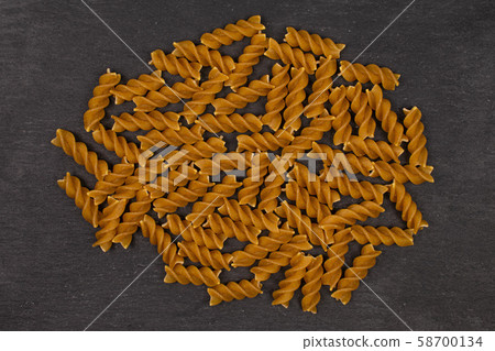Dry wholegrain fusilli on grey stone 58700134