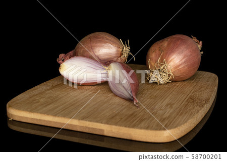 Fresh brown shallot isolated on black glass Fresh brown shallot isolated on black glass 58700201