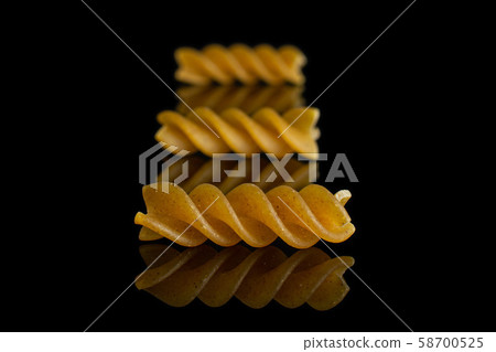 Dry wholegrain fusilli isolated on black glass Dry wholegrain fusilli isolated on black glass 58700525