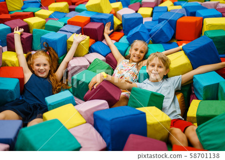 Happy children lying in soft cubes, playroom 58701138