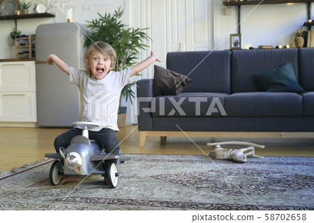 Little boy sits on the airplane and plays on the floor Little boy sits on the airplane and plays on the floor 58702658