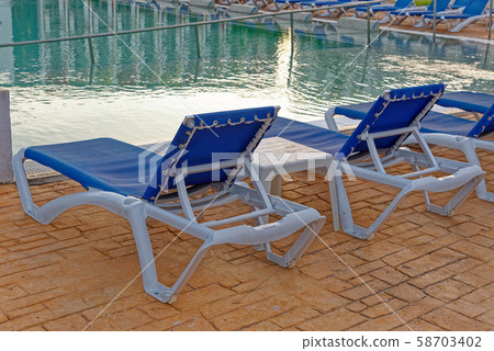 Beach chairs near swimming pool Beach chairs near swimming pool 58703402