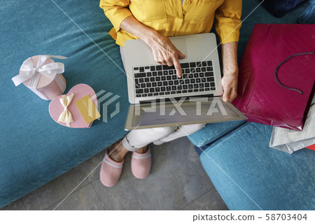 Woman is typing on laptop in loving room Woman is typing on laptop in loving room 58703404